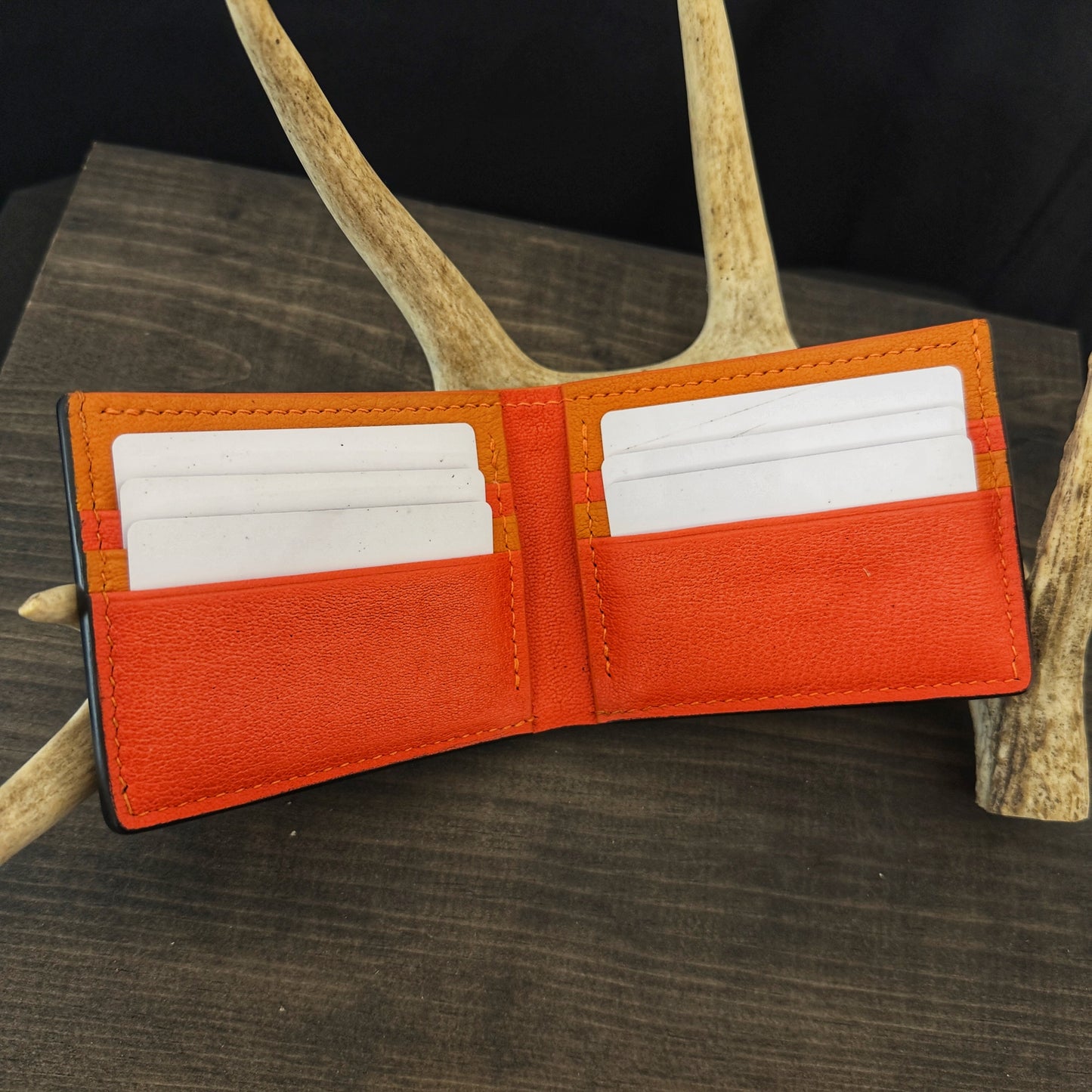 Buster Bifold Wallet. Black with Orange Goat Leather Interior. Orange Stitch. #157